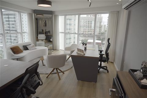 Ambiente de atendimento com mesas, poltronas e vista para a cidade